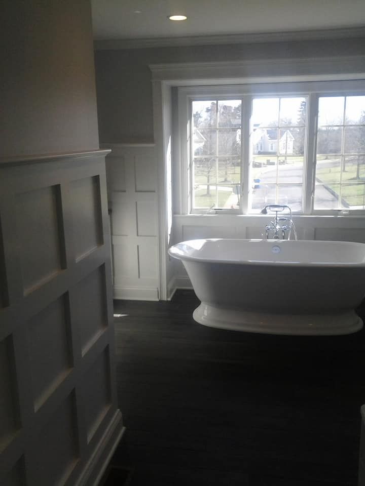 A bathroom with a bathtub and a window