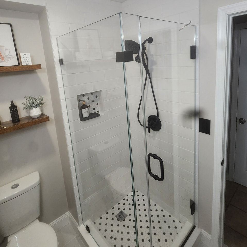 A bathroom with a toilet and a shower stall