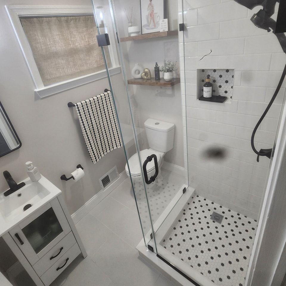 A bathroom with a toilet a sink and a walk in shower