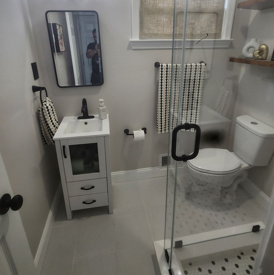 A bathroom with a toilet a sink and a mirror