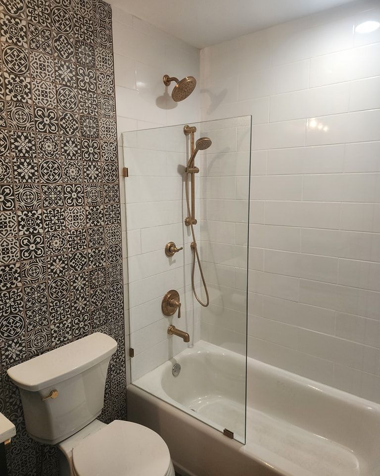 A bathroom with a toilet , tub and shower.