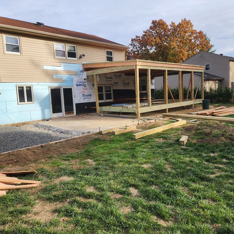 A house is being remodeled with a wooden structure in the backyard