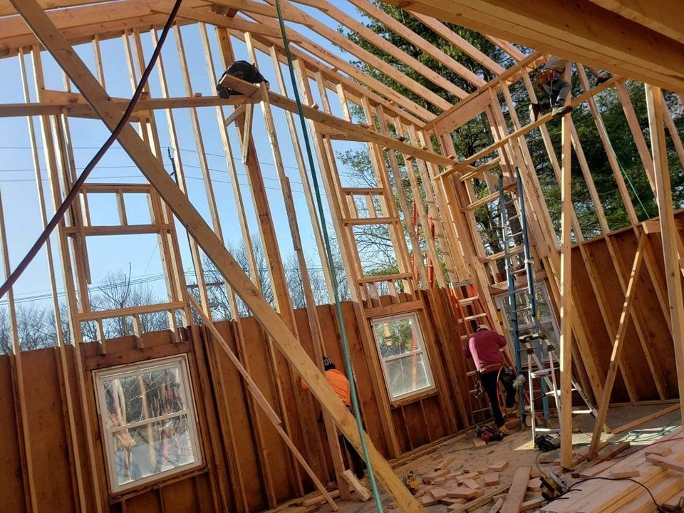 A house is being built with wooden beams and a ladder.