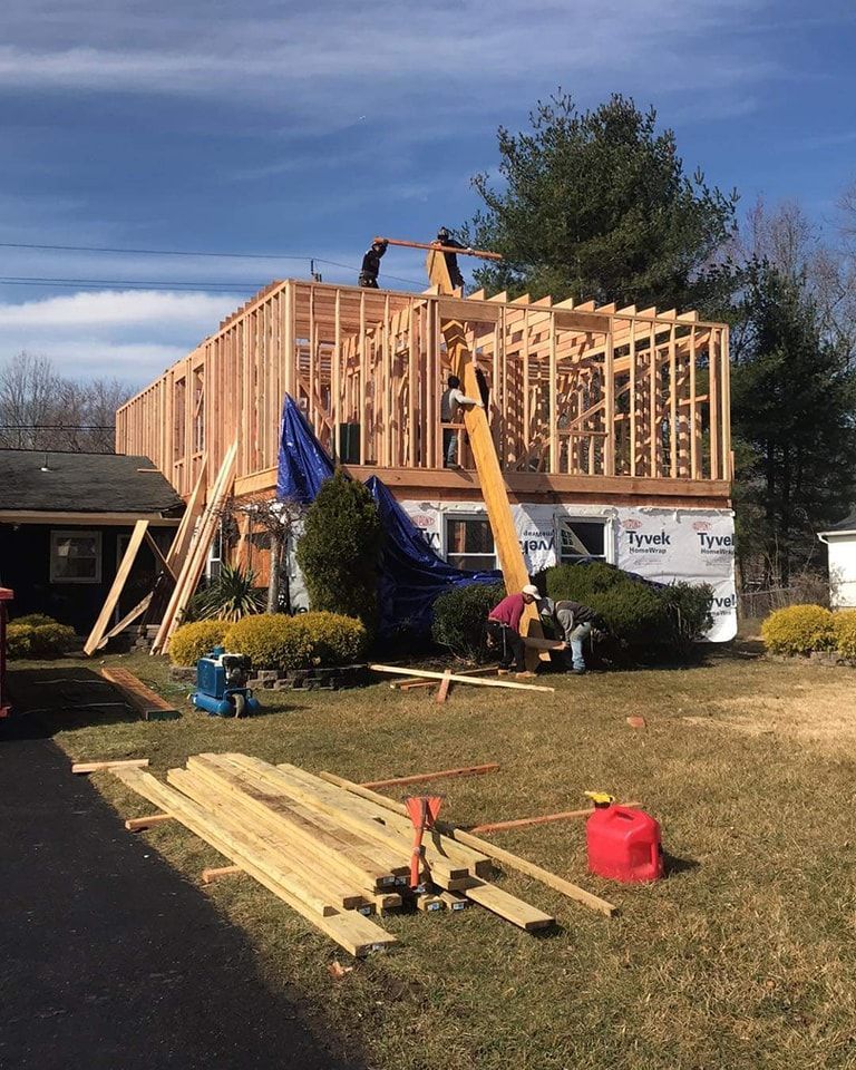 A house is being built with a crane in the backyard.