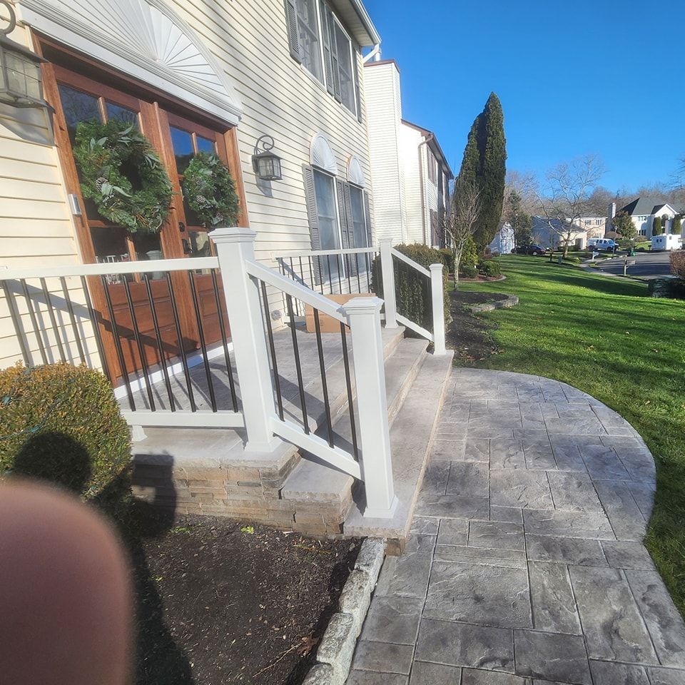 A walkway leading to a house with a white railing
