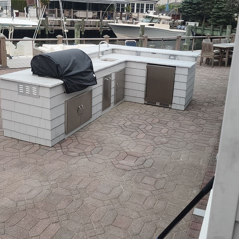 An outdoor kitchen with a grill and a sink