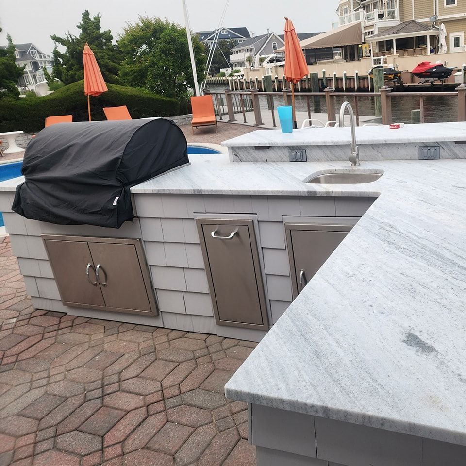 An outdoor kitchen with a grill and a sink