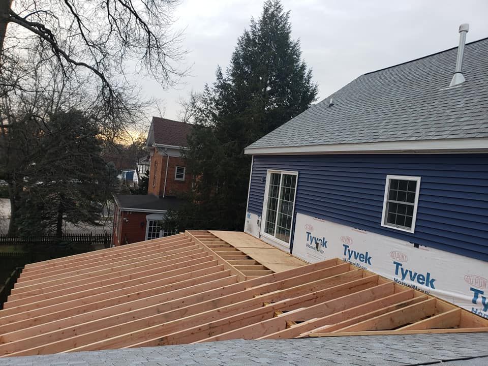 A blue house with a roof is being built.
