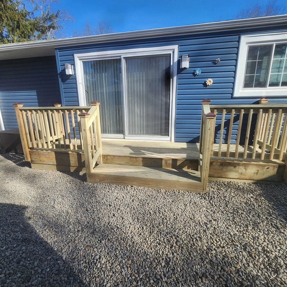 A blue house with a wooden deck in front of it