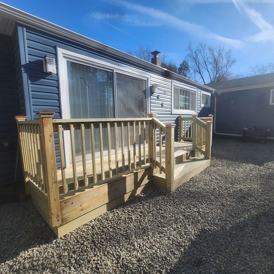 A blue house with a wooden deck in front of it