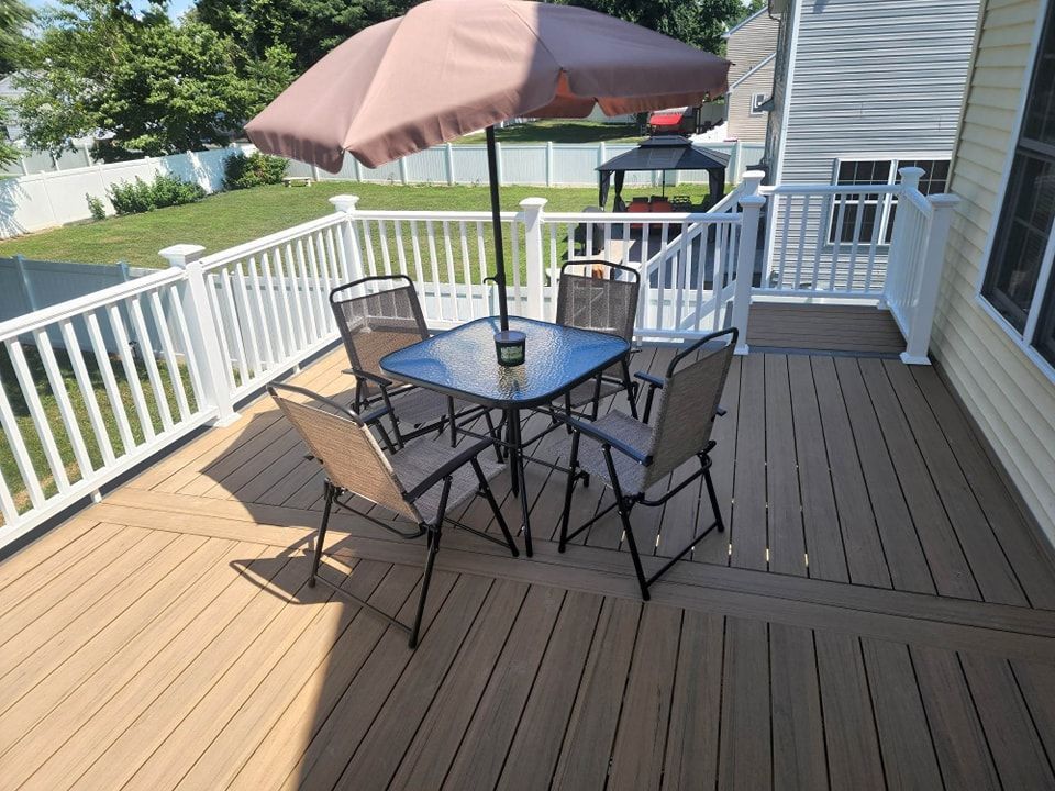 A deck with a table and chairs under an umbrella