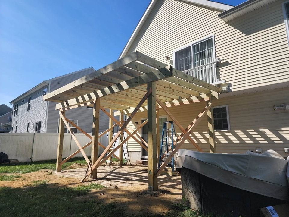 A wooden deck is being built in the backyard of a house.