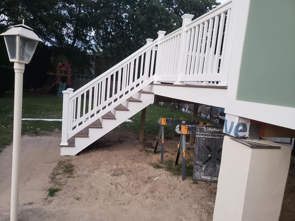 A white deck with stairs and a lamp post