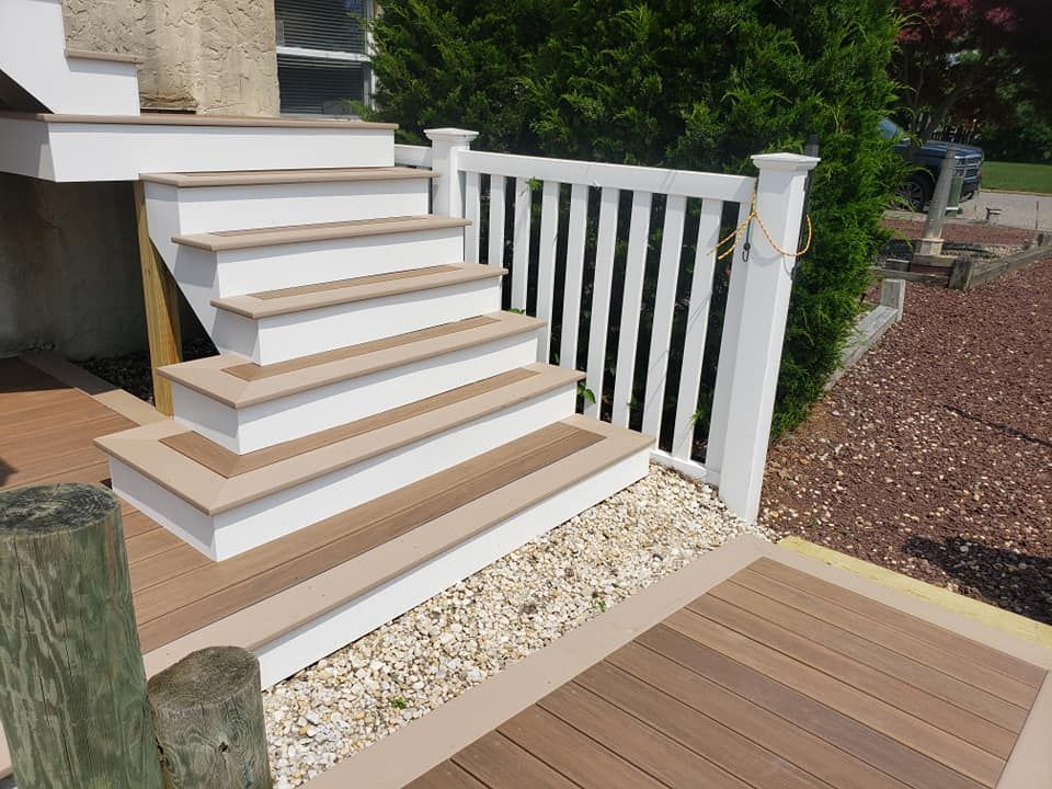 A wooden deck with stairs and a white railing