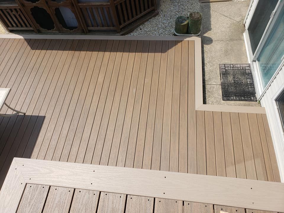 A wooden deck with stairs and a hot tub in the background