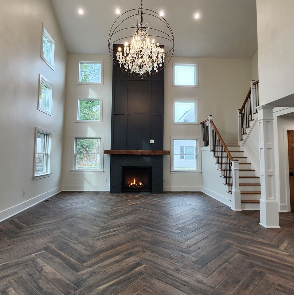An empty living room with a fireplace and stairs