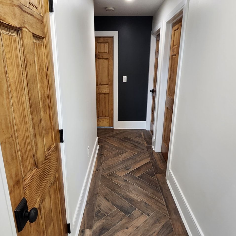 A hallway with wooden floors and white walls
