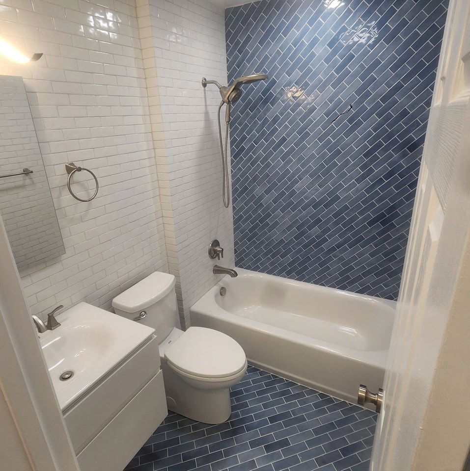 A bathroom with a toilet, sink, bathtub, and shower