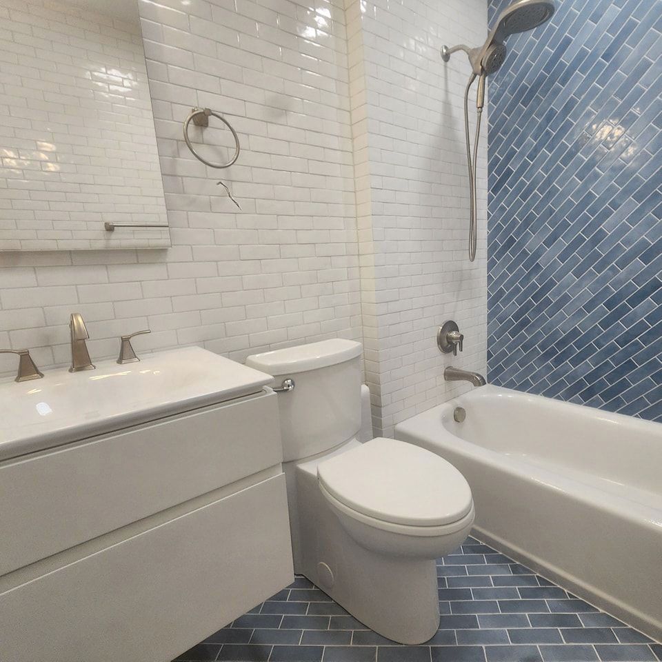 A bathroom with a toilet, sink, shower, and bathtub