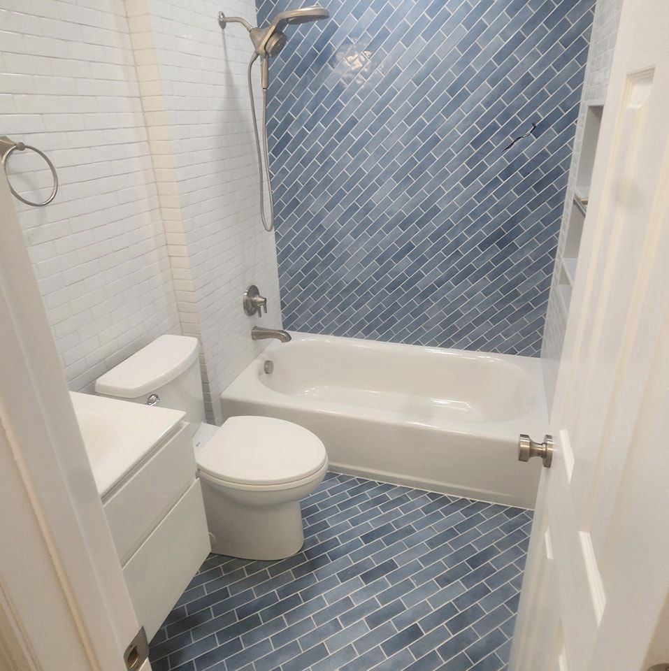 A bathroom with a toilet, a bathtub, and a shower