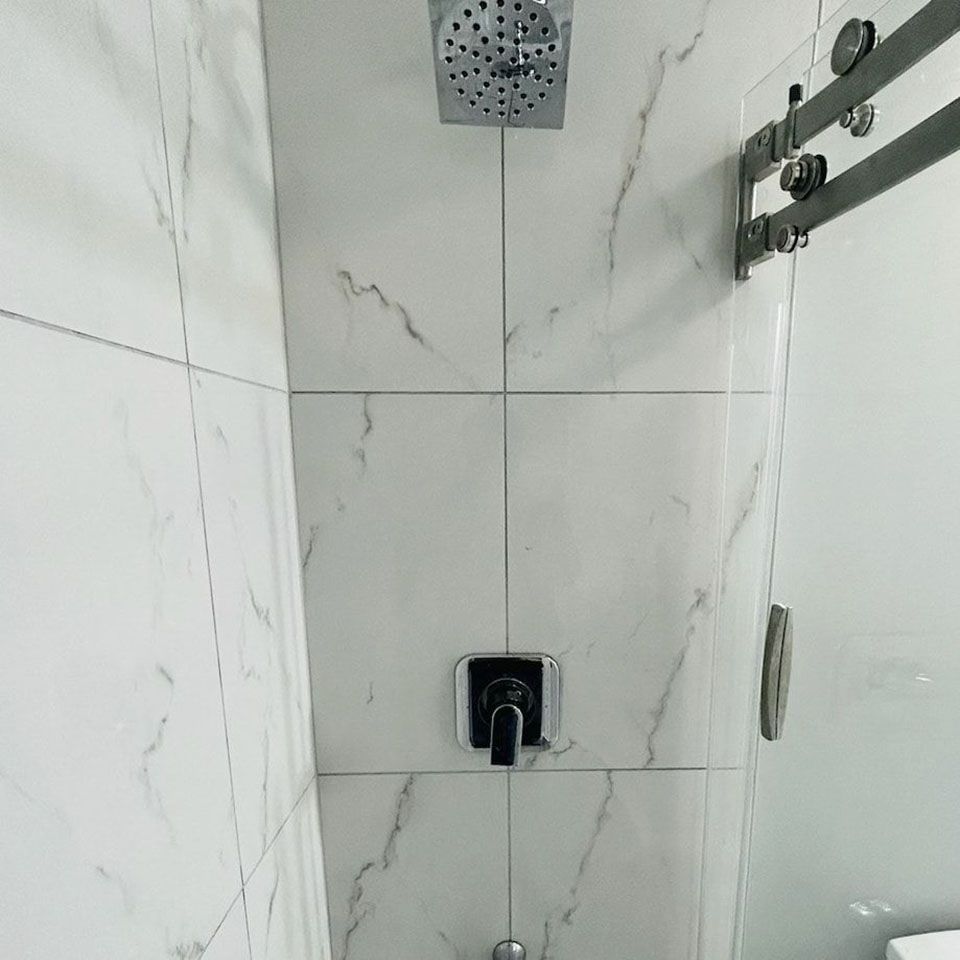 A bathroom with a shower head and a toilet