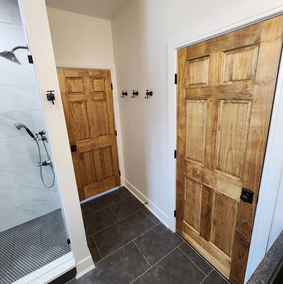 A bathroom with a shower and two wooden doors