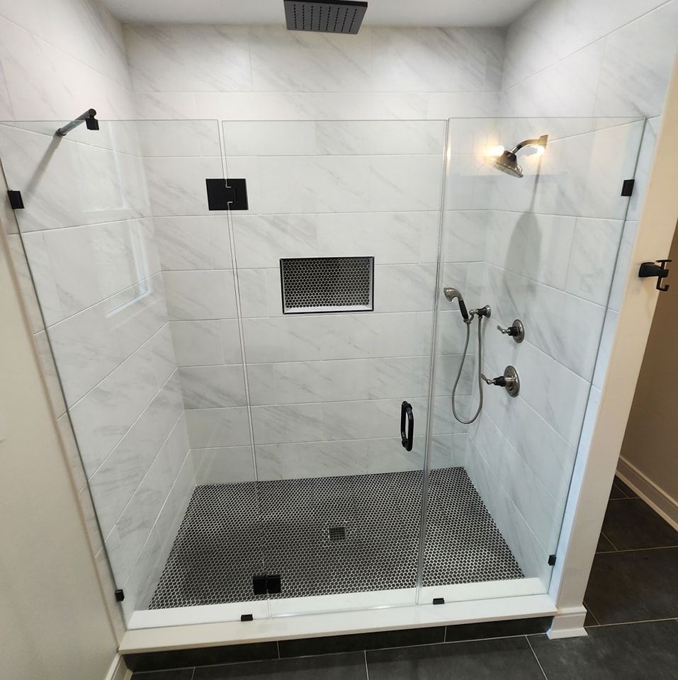 A shower with a glass door and a shower head