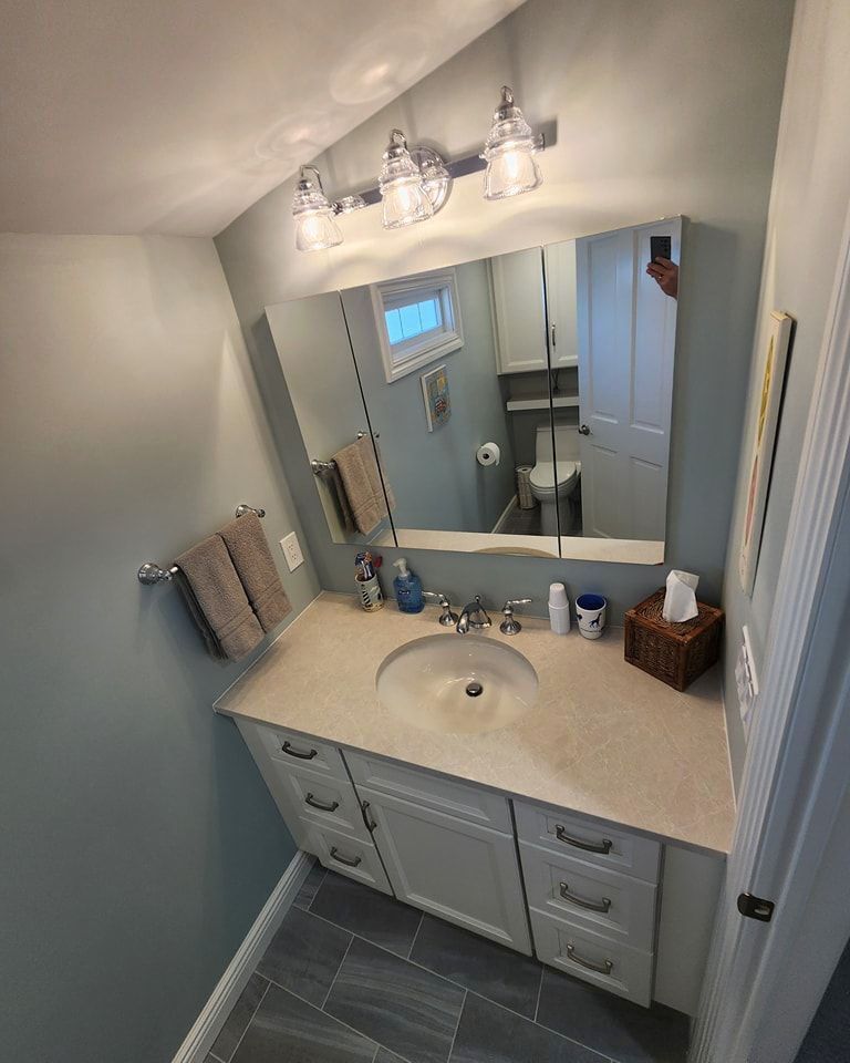 A bathroom with a sink, mirror, and toilet