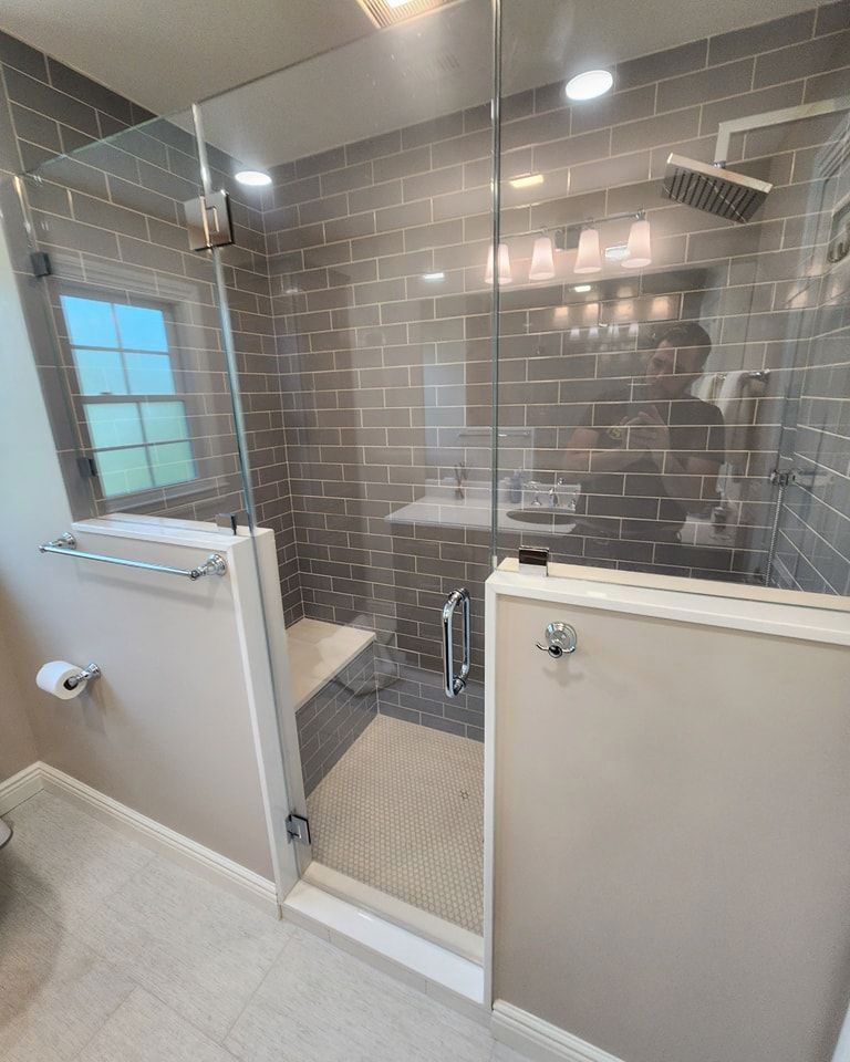 A bathroom with a walk-in shower with a glass door