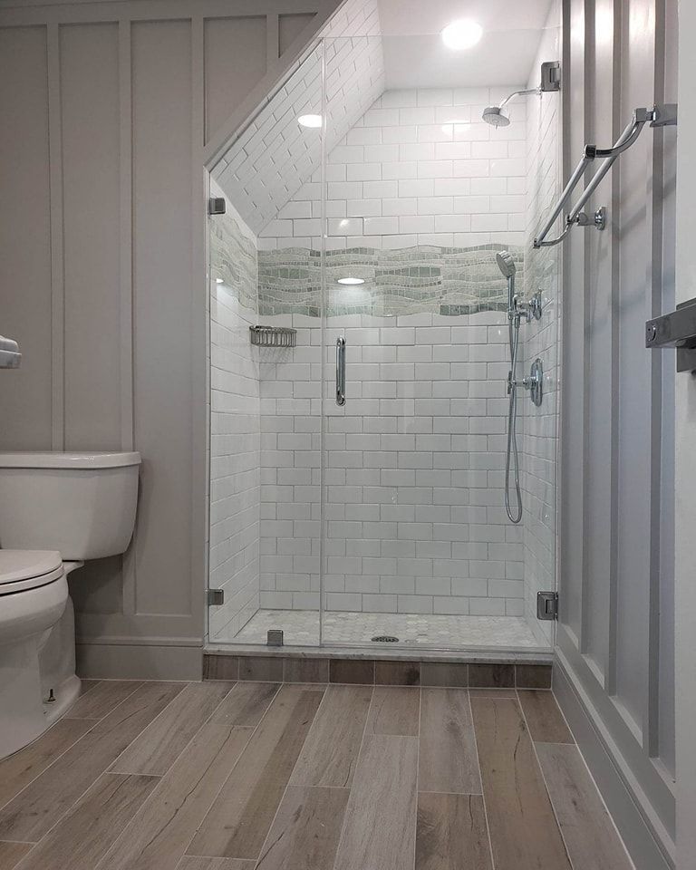 A bathroom with a toilet and a walk-in shower with a glass door