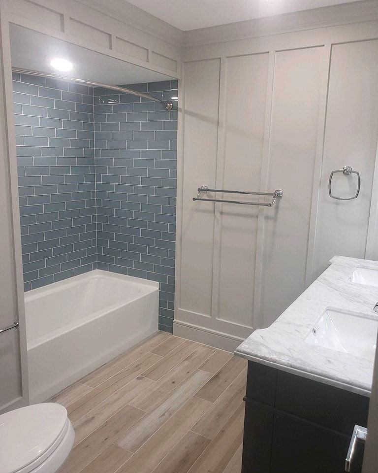 A bathroom with a tub, sink, toilet, and shower