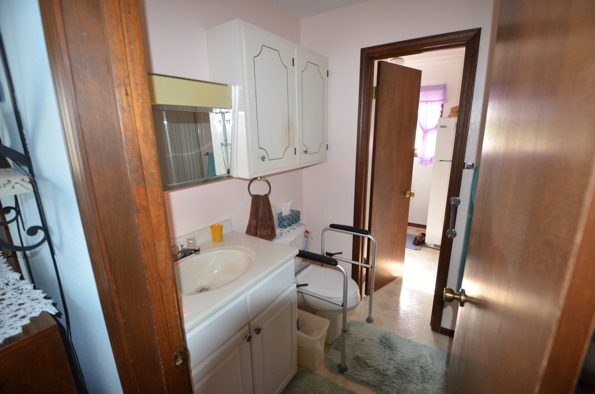 A bathroom with a sink , toilet and a walker