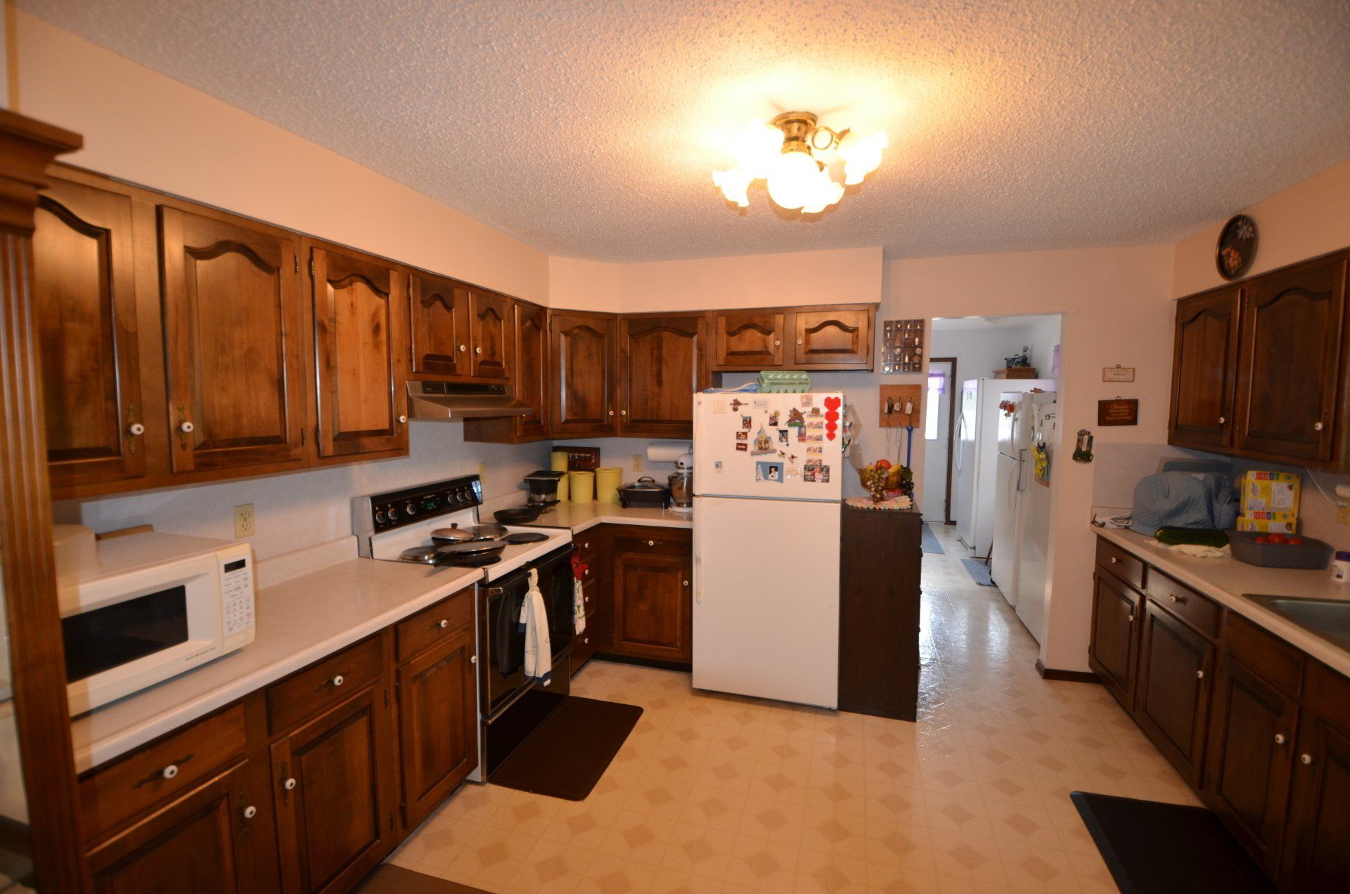 A kitchen with wooden cabinets and a white refrigerator