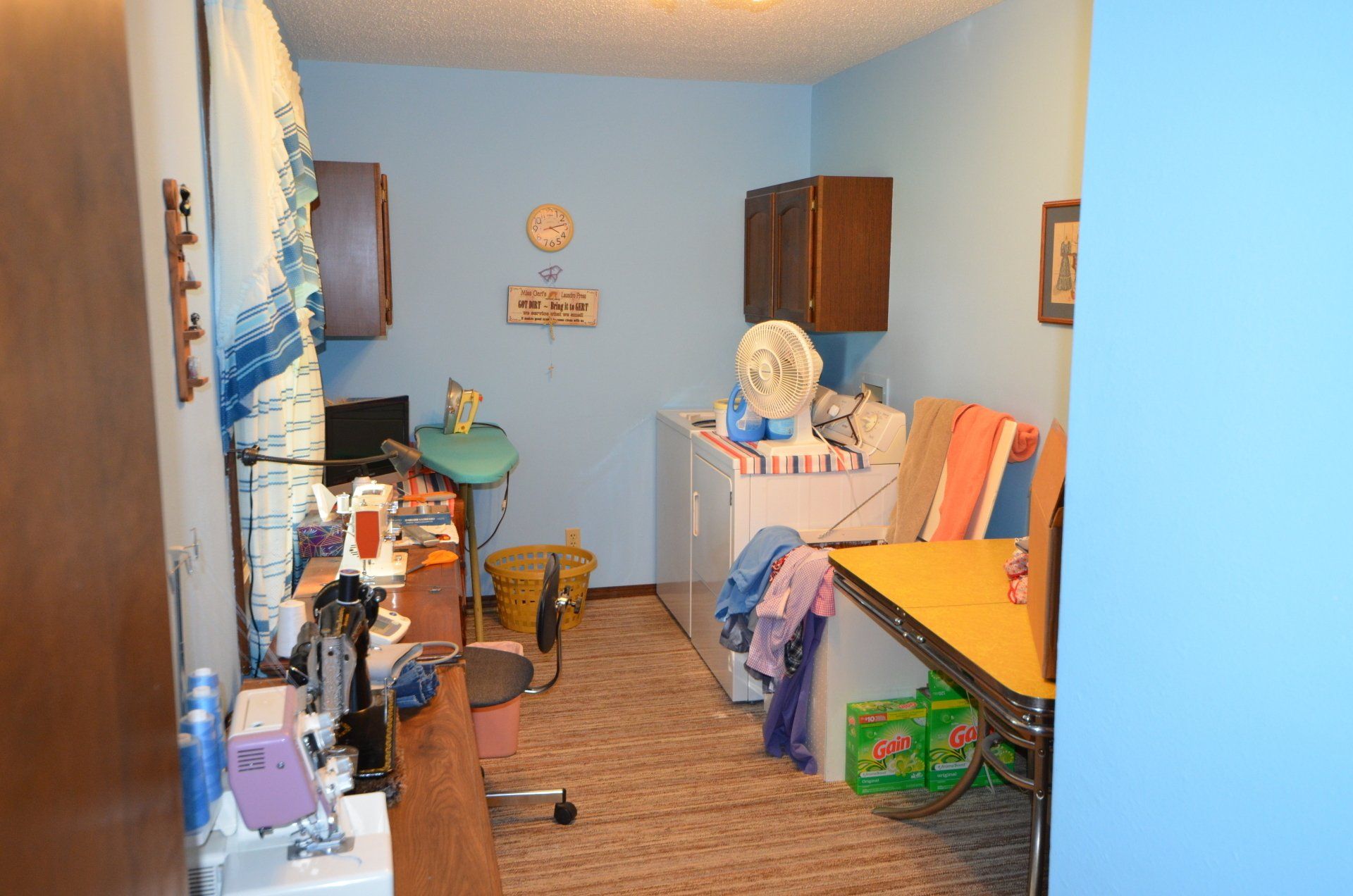 A laundry room with a sewing machine and a washing machine