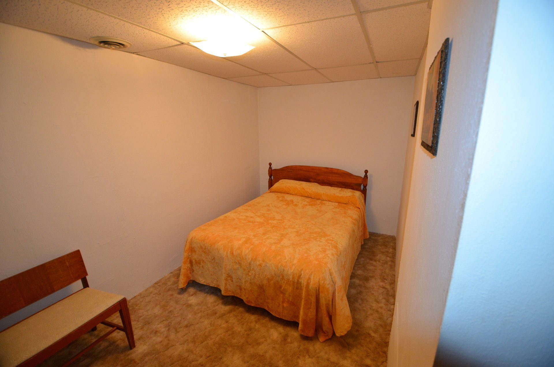 A bedroom with a bed and a bench in it.