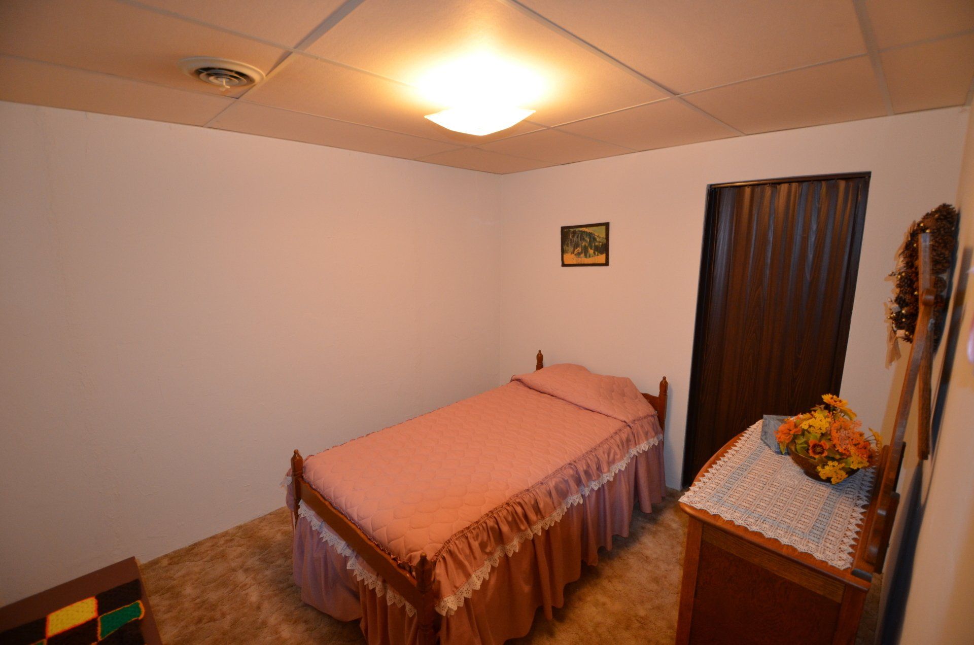 A bedroom with a single bed and a dresser