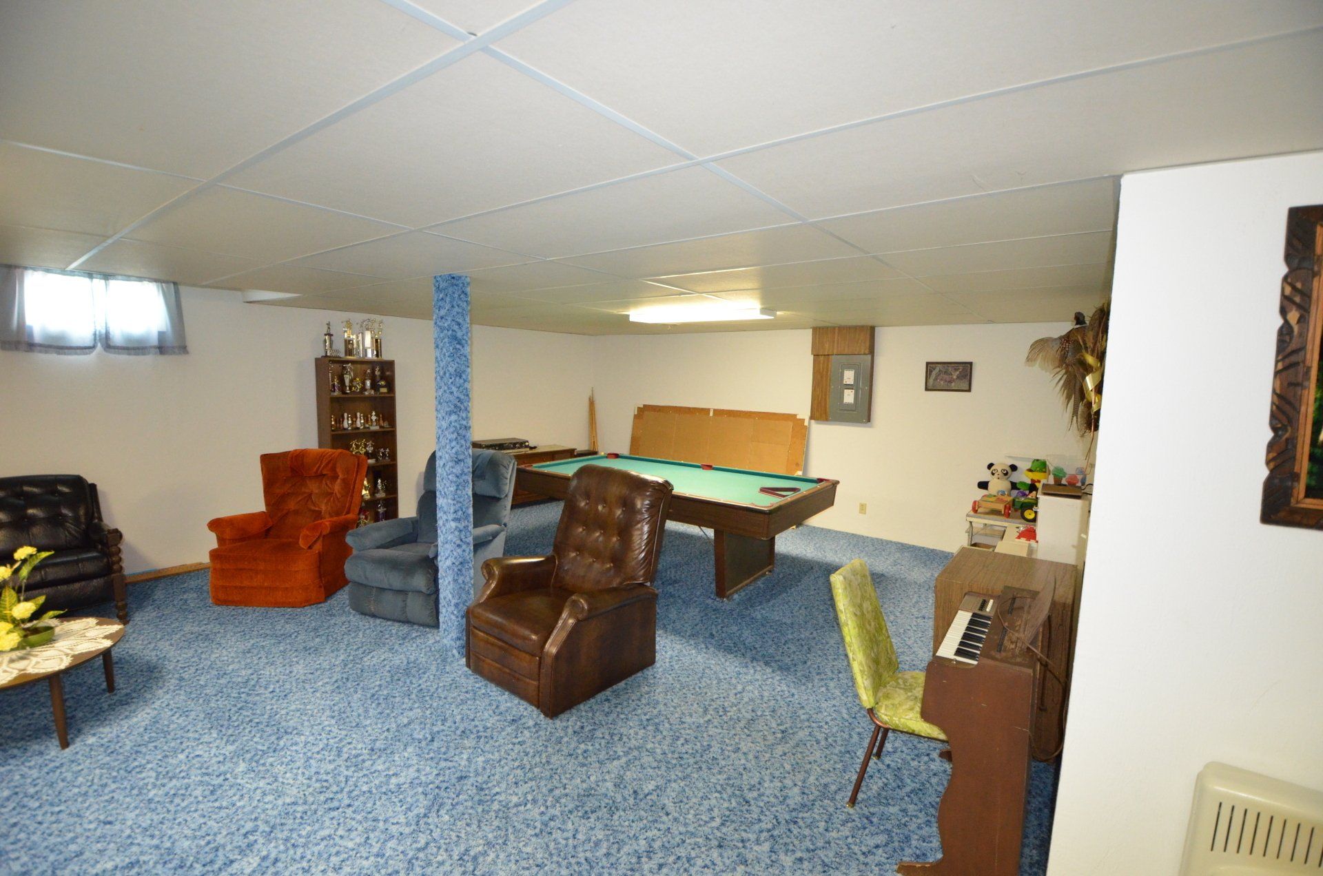 A living room with a pool table and chairs