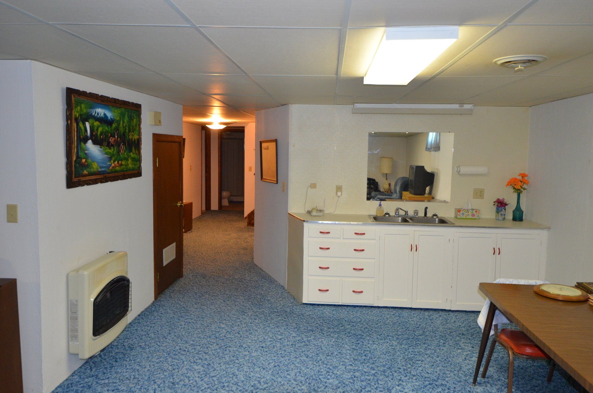 A kitchen with a sink and a picture on the wall
