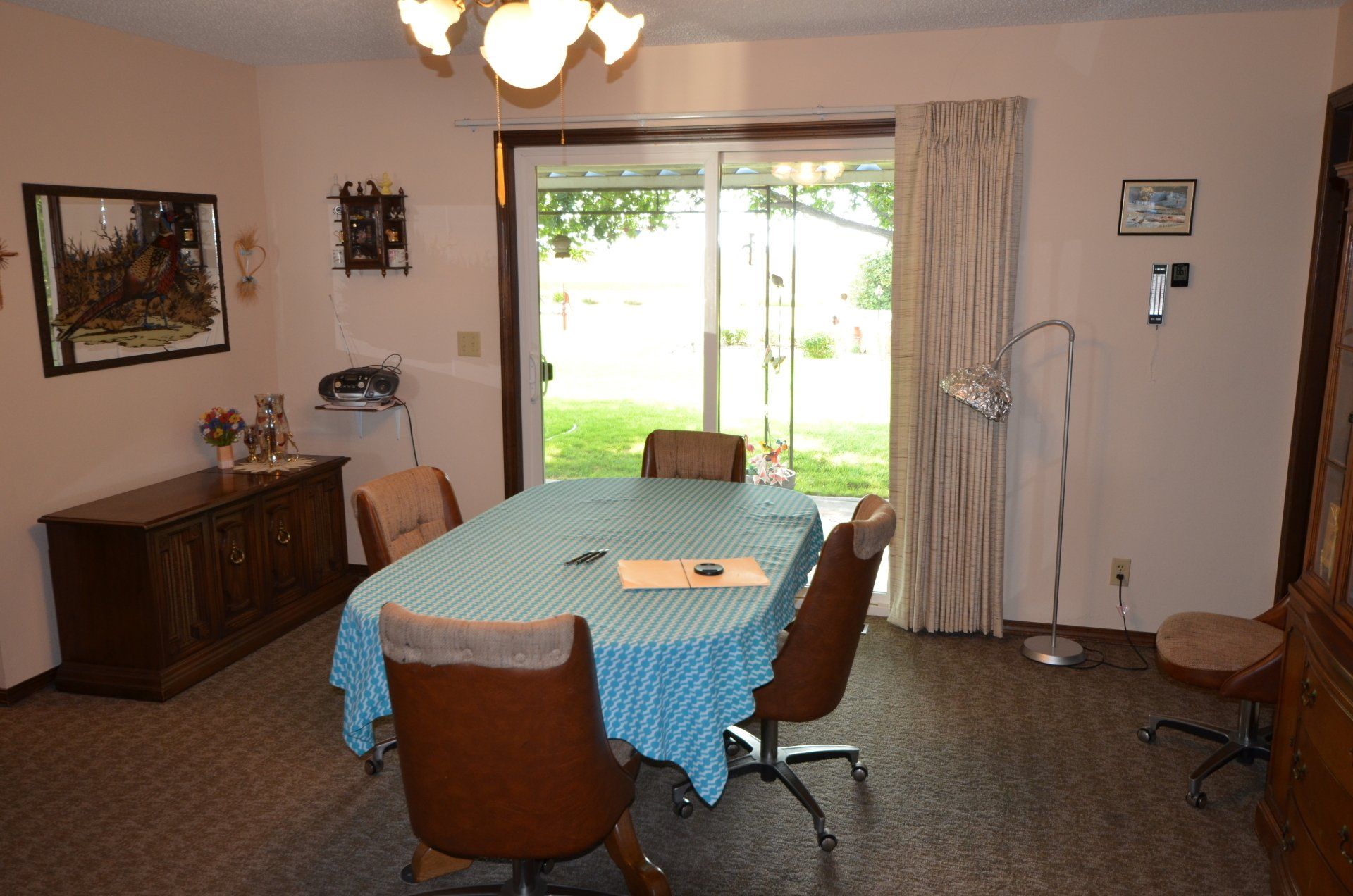 A dining room with a table and chairs and a sliding glass door