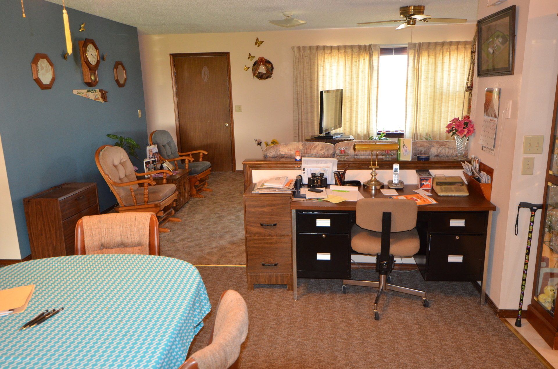 A living room with a table and chairs and a desk