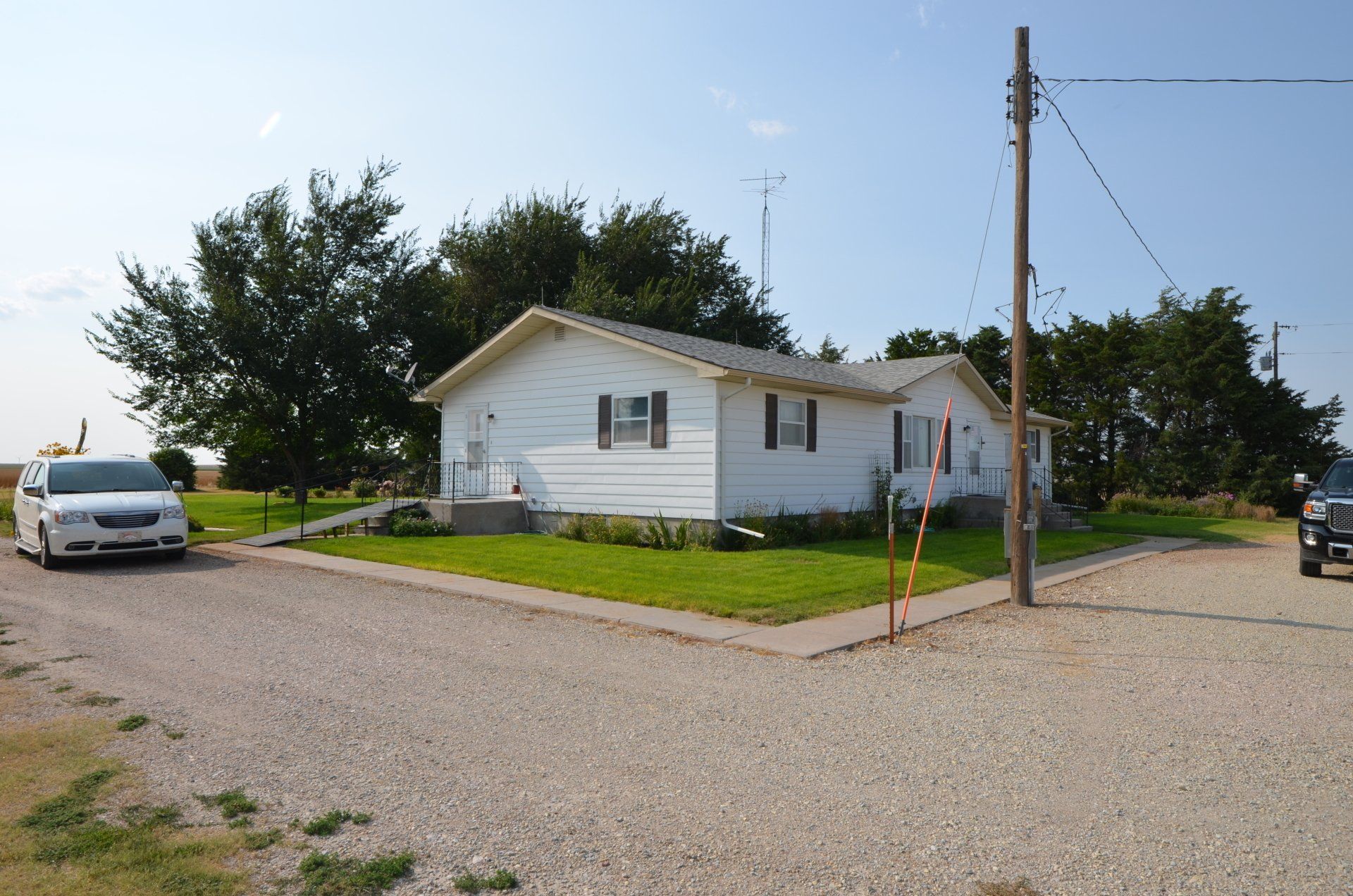 A white van is parked in front of a white house