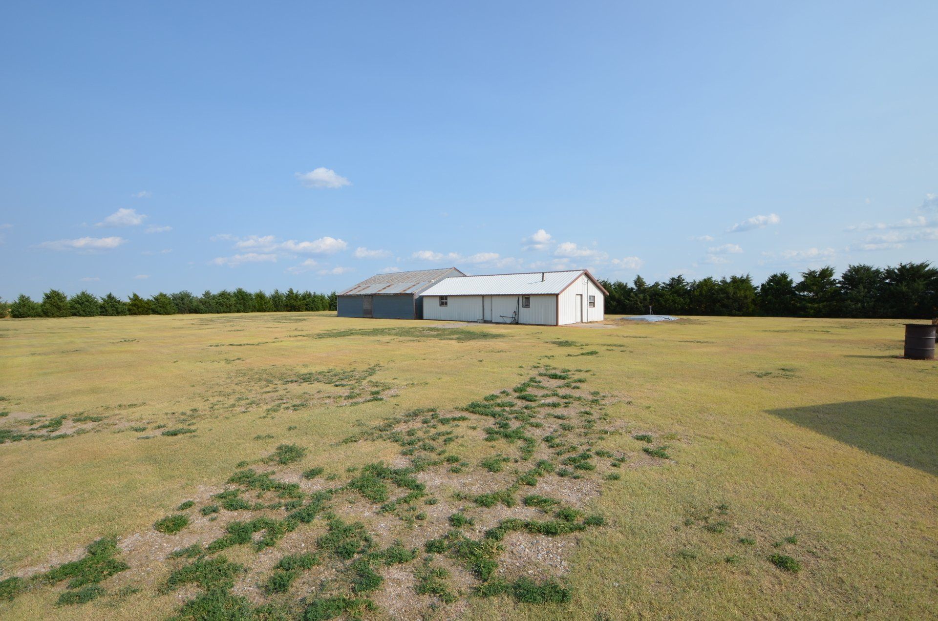 A large grassy field with a house in the background