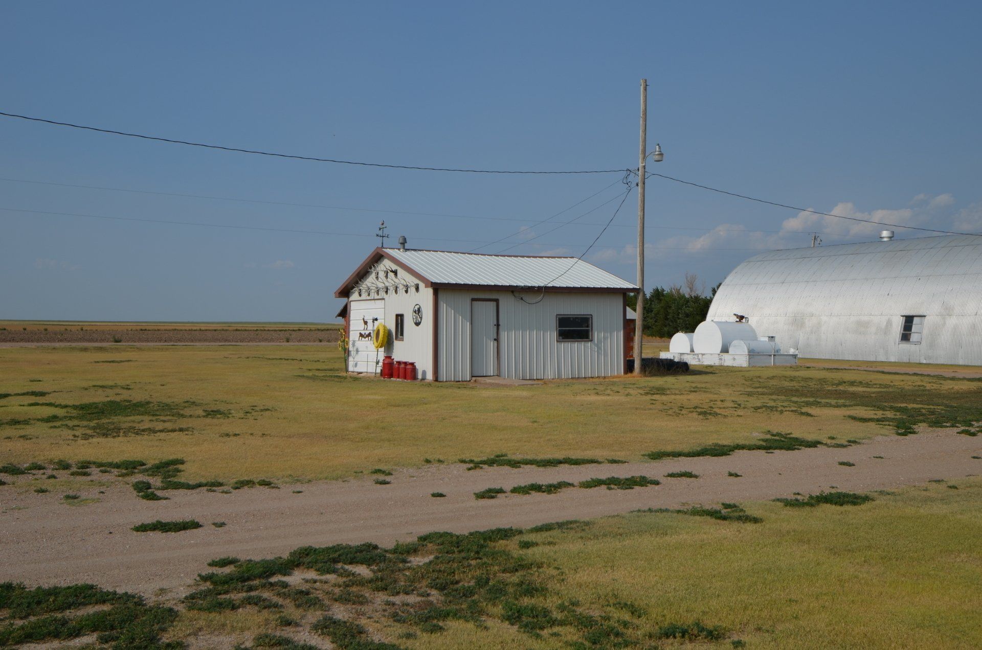 A small white building in the middle of a field