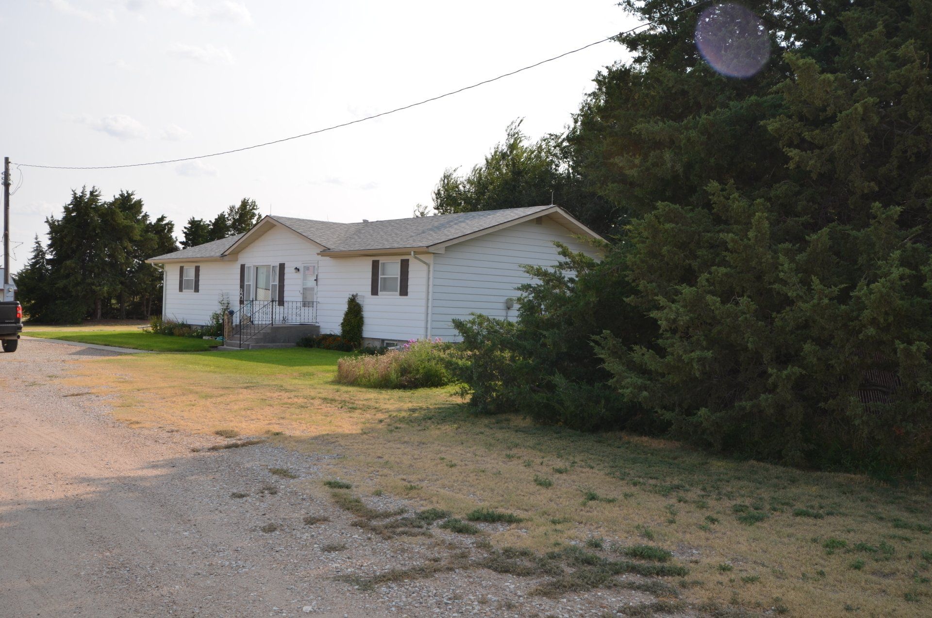 A white house with a black truck parked in front of it
