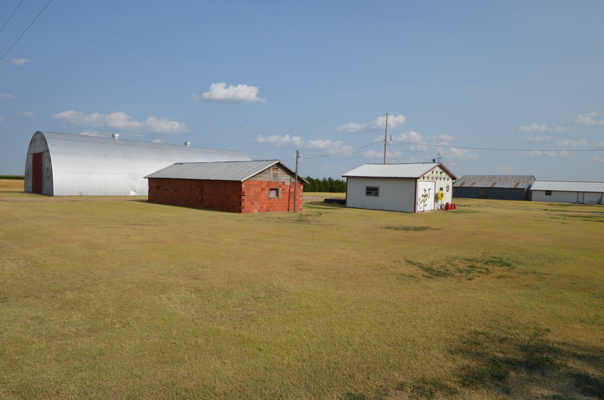 A group of buildings are sitting on top of a lush green field.