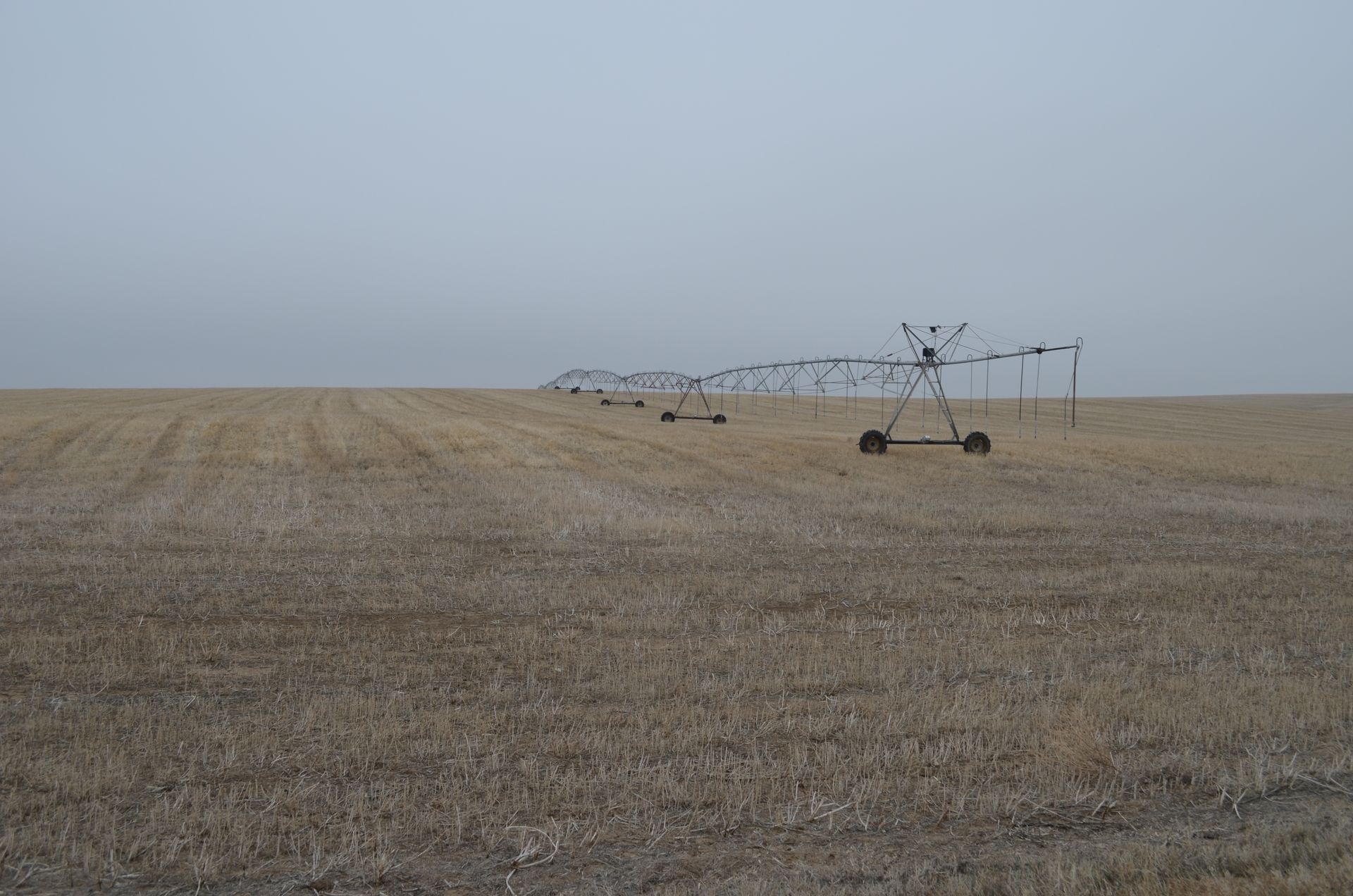 A row of irrigation systems in a dry field