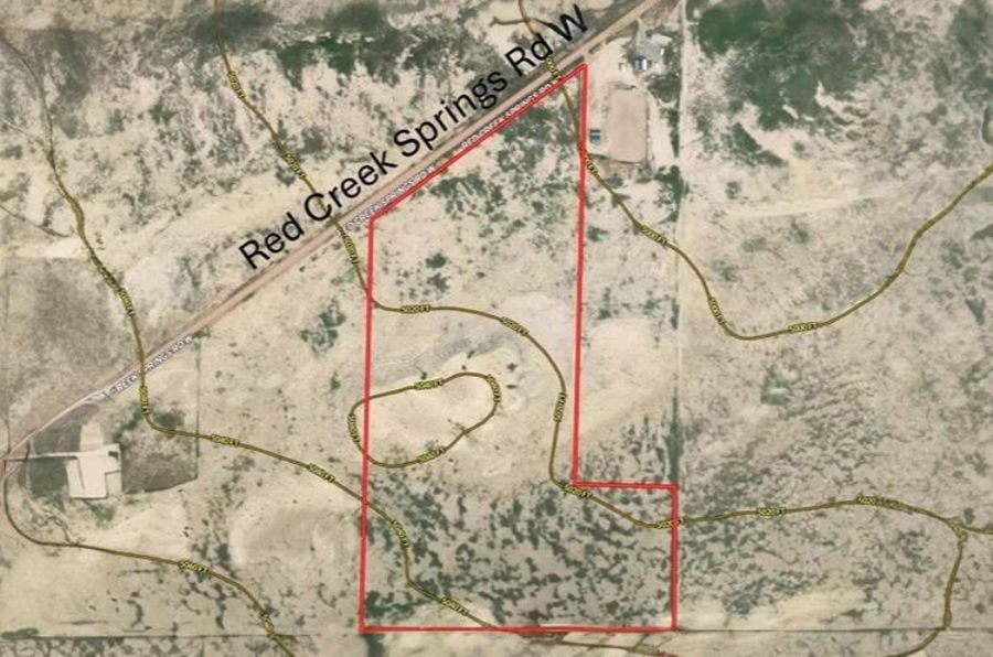 Aerial view of a rectangular plot of land outlined in red near Red Creek Springs Rd W, sparse vegetation.