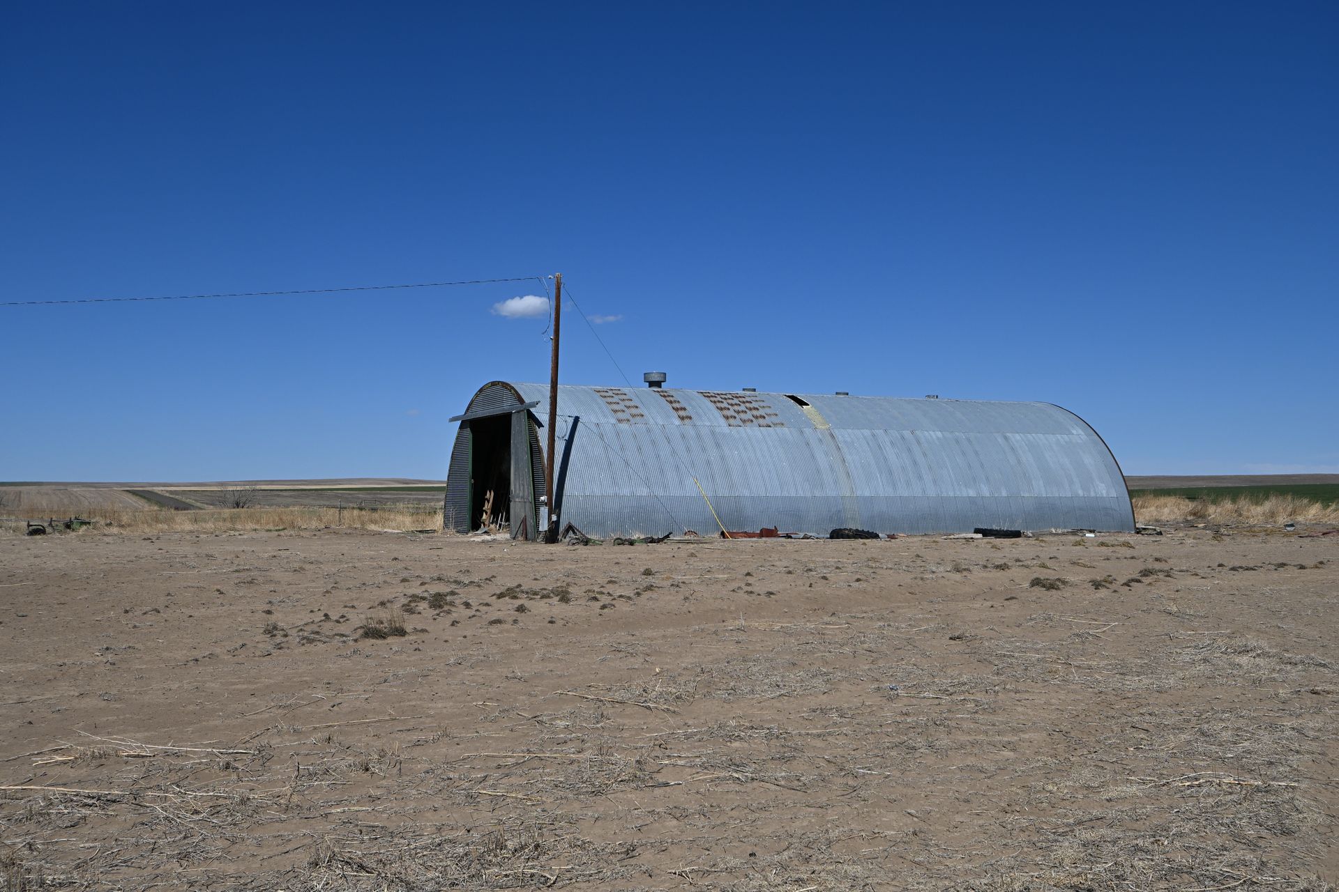 Small corrugated metal shed in a barren desert under a clear blue sky