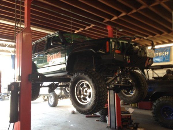 Black pickup vehicle being lifted