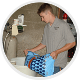 a man in a grey shirt is pouring salt into a softener